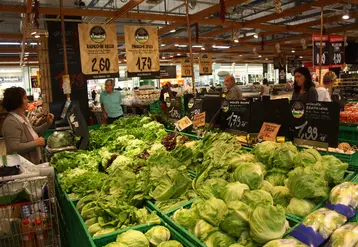 Consommateurs faisant leurs achats, dans un rayon de salades d'un supermarché en Italie.